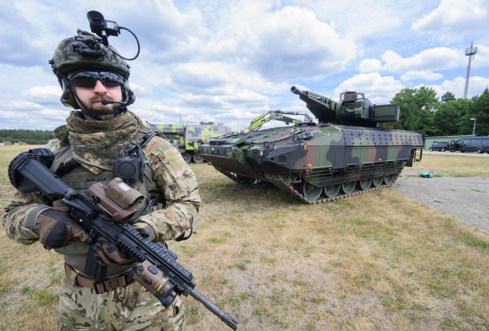 Ein Infanterist der Bundeswehr steht vor einem Puma-Panzer. - Copyright: picture alliance/dpa | Julian Stratenschulte