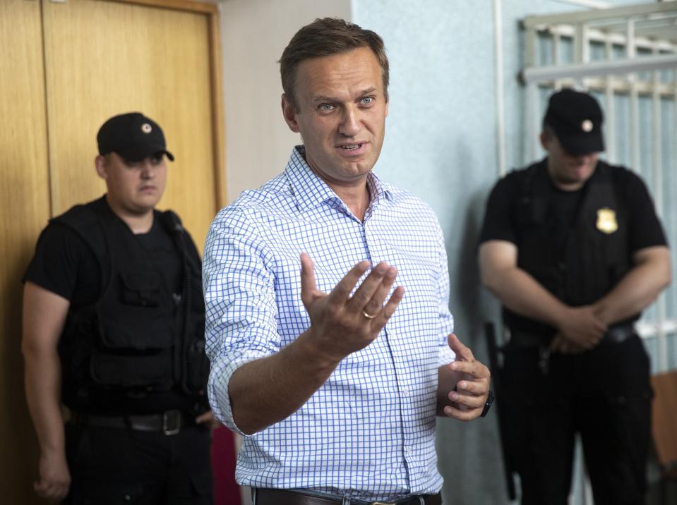 Russian opposition activist Alexei Navalny, left, gestures in a court before a hearing in Moscow, Russia, Monday, July 1, 2019. A Moscow court jailed Russian opposition leader Alexei Navalny for 10 days on Monday after finding him guilty of breaking the law when he took part in a street demonstration last month. (AP Photo/Pavel Golovkin)
