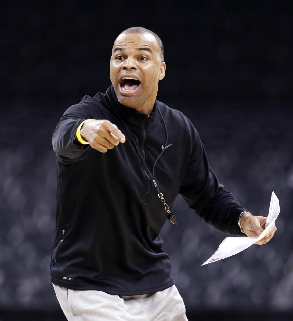 FILE - In this March 19, 2014, file photo, Harvard head coach Tommy Amaker directs his team during practice for the NCAA college basketball tournament in Spokane, Wash. When George Floyd died this spring under a policeman's knee, Amaker didn't send out a tweet affirming Black Lives Matter or add a uniform patch calling for Equality. He simply continued exposing his players to social justice issues, as he had been doing for more than a decade, establishing the program as a model for other teams only now showing an interest. (AP Photo/Elaine Thompson, File)