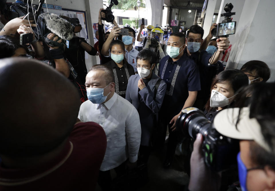 Rappler CEO and Executive Editor Maria Ressa, center, is escorted as she arrives to attend a court hearing at Manila Regional Trial Court, Philippines on Monday June 15, 2020. Ressa's verdict is expected to be announced Monday for a cyber libel case. (AP Photo/Aaron Favila)