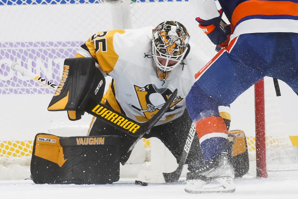 Pittsburgh Penguins goaltender Tristan Jarry (35) makes a save against the New York Islanders' Kyle Palmieri (21) in the first period of an NHL hockey game, Friday, Nov. 26, 2021, in Elmont, N.Y. (AP Photo/Eduardo Munoz Alvarez)