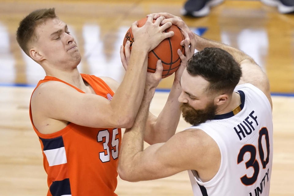 Virginia forward Jay Huff (30) battles for a rebound with Syracuse guard Buddy Boeheim (35) during the second half of an NCAA college basketball game in the quarterfinal round of the Atlantic Coast Conference tournament in Greensboro, N.C., Thursday, March 11, 2021. (AP Photo/Gerry Broome)