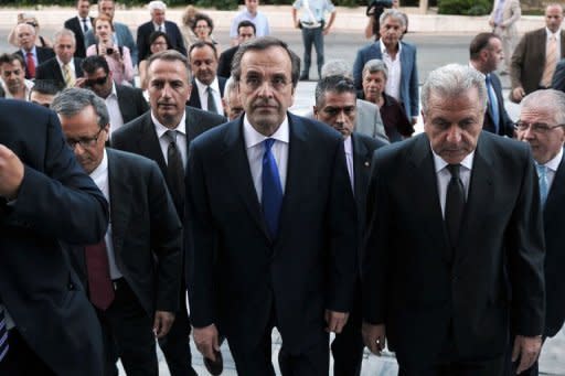 Greece's new Prime Minister Antonis Samaras (C) and Foreign minister Dimitris Avramopoulos (R), flanked by security and newly appointed ministers, arrive at the Greek parliament for their first cabinet meeting