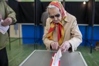 A woman casts her ballot at a polling station during a first round of voting in presidential elections in Vilnius, Lithuania, Sunday, May 12, 2024. (AP Photo/Mindaugas Kulbis)