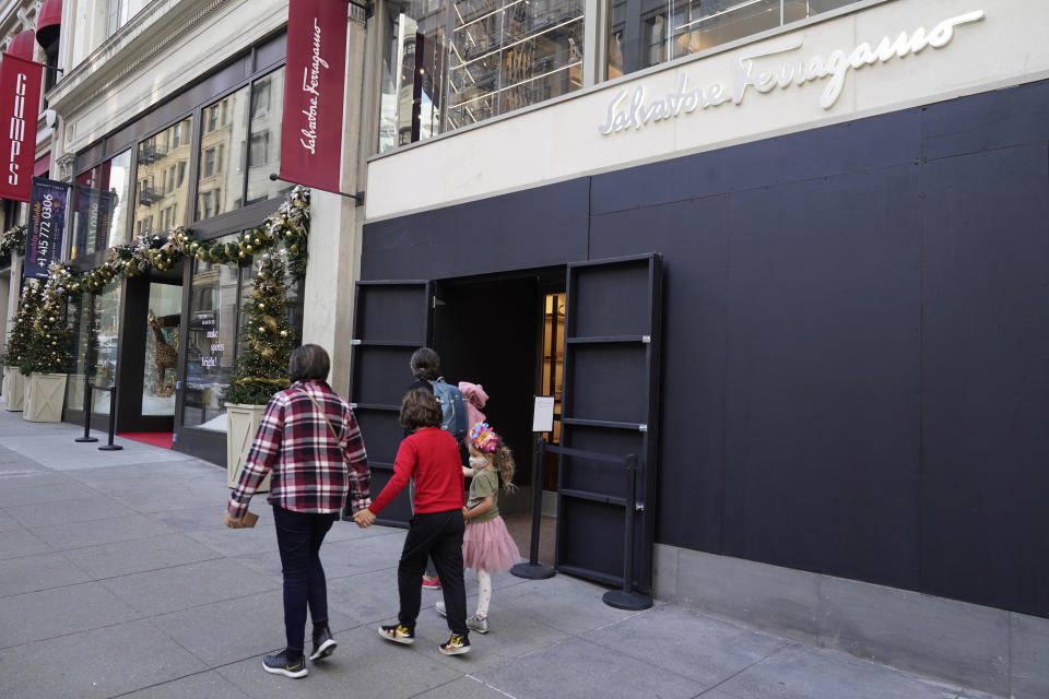 People walk past a boarded storefront window following recent robberies near Union Square in San Francisco on Dec. 2, 2021. A fed-up Mayor London Breed announced Tuesday, Dec. 14, 2021, San Francisco will dramatically crack down on open drug use and sales and illegal vending of stolen goods that's fueled smash and grab robberies. (AP Photo/Eric Risberg)