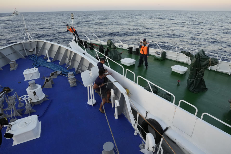 Crew of Philippine coast guard ship BRP Sindangan, left, places rubber fenders against a Chinese coast guard ship during a collision as they tried to enter the Second Thomas Shoal, locally known as Ayungin Shoal, during a resupply mission in the disputed South China Sea Tuesday, March 5, 2024. Chinese and Philippine coast guard vessels collided in the disputed South China Sea and multiple Filipino crew members were injured in high-seas confrontations Tuesday as Southeast Asian leaders gathered for a summit that was expected to touch on Beijing's aggression at sea. (AP Photo/Aaron Favila)