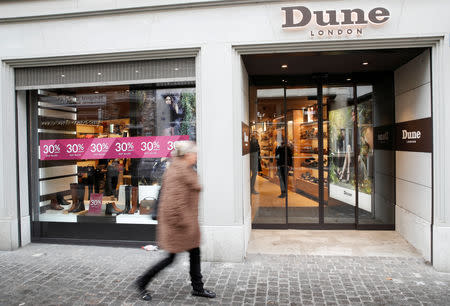 FILE PHOTO: A woman walks past a shop of British fashion footwear and accessories company Dune London in Zurich, Switzerland December 10, 2018. REUTERS/Arnd Wiegmann/File Photo