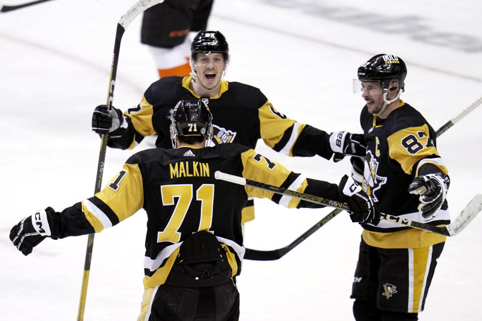 Pittsburgh Penguins' Rickard Rakell celebrates his first of two goals during the first period, with Evgeni Malkin (71) and Sidney Crosby (87), during an NHL hockey game in Pittsburgh, Sunday, April 2, 2023. (AP Photo/Gene J. Puskar)