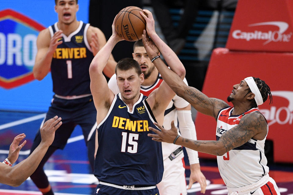 Washington Wizards guard Bradley Beal (3) reaches for the ball against Denver Nuggets center Nikola Jokic (15) during the first half of an NBA basketball game, Wednesday, Feb. 17, 2021, in Washington. (AP Photo/Nick Wass)