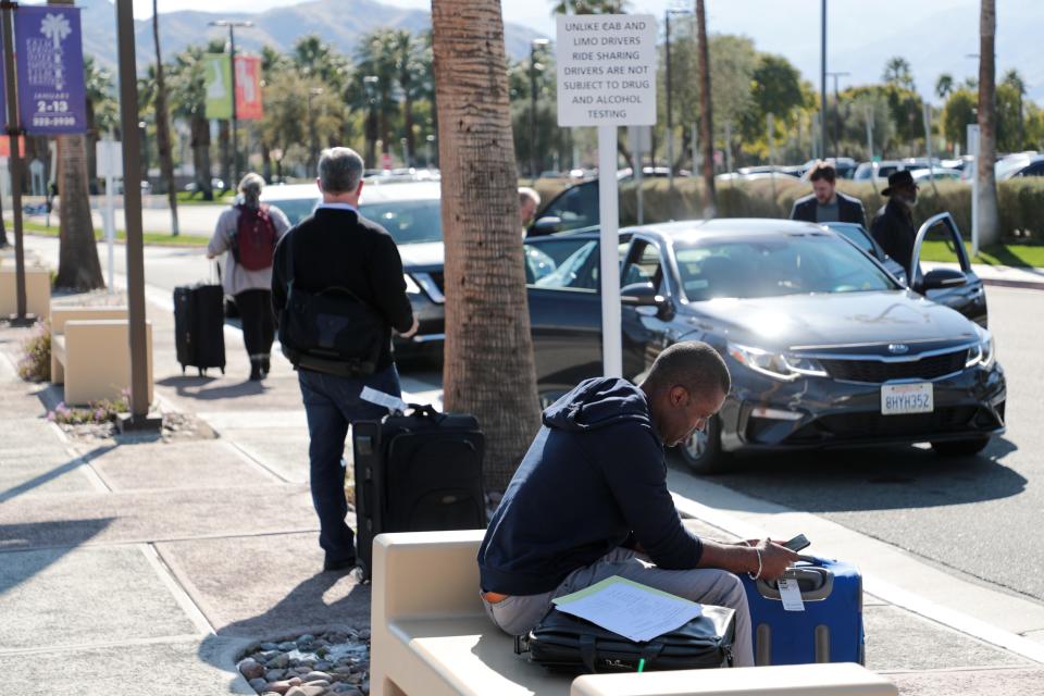 Passengers wait to be picked up by ride share services at Palm Springs International Airport on Wednesday, Jan. 22, 2020 in Palm Springs, Calif.