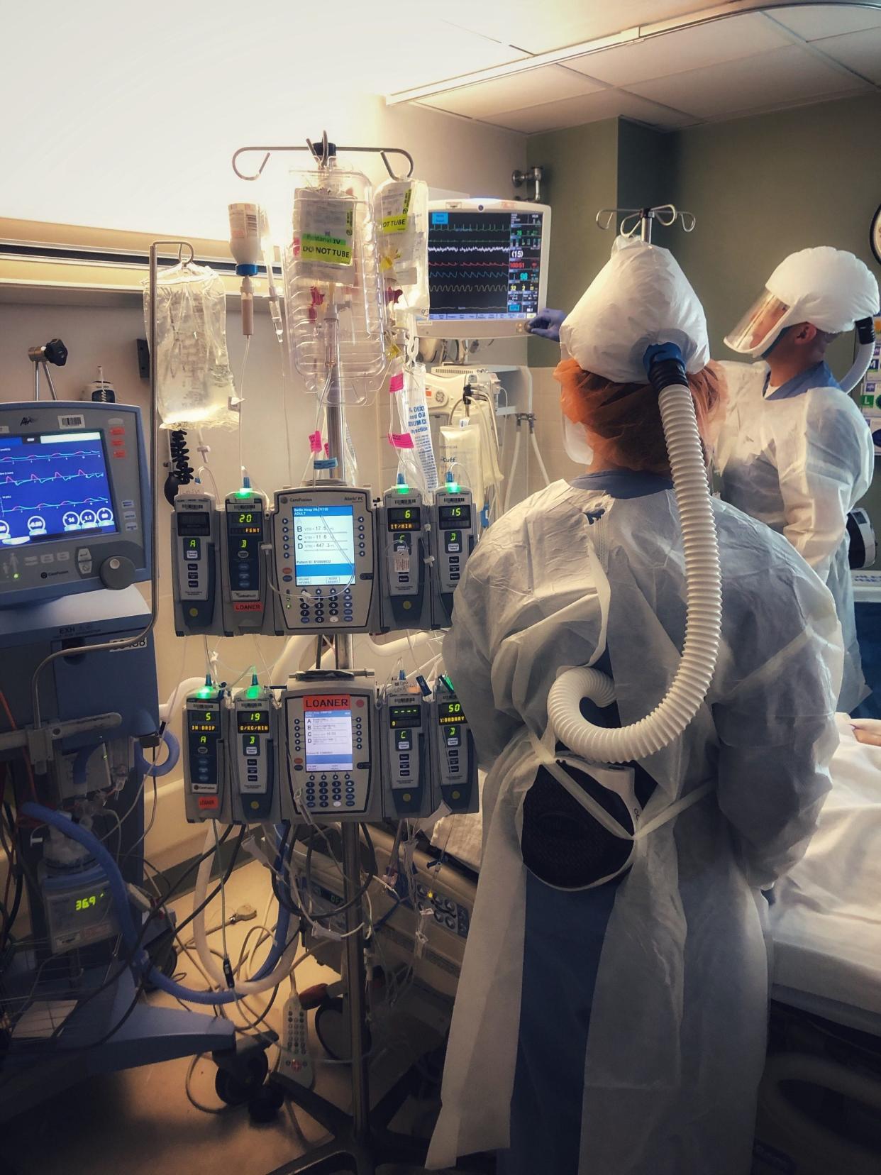 Two medical staff members work with a COVID-19 patient at Bellin Hospital.