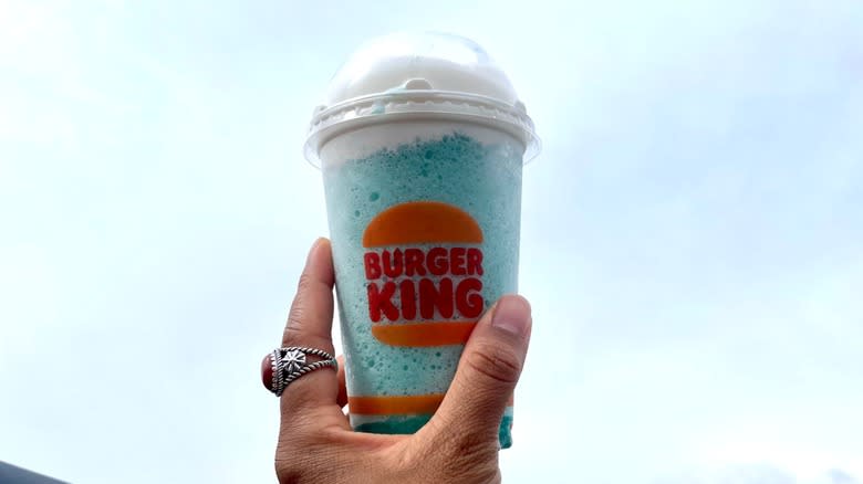 holding burger king slushie cup