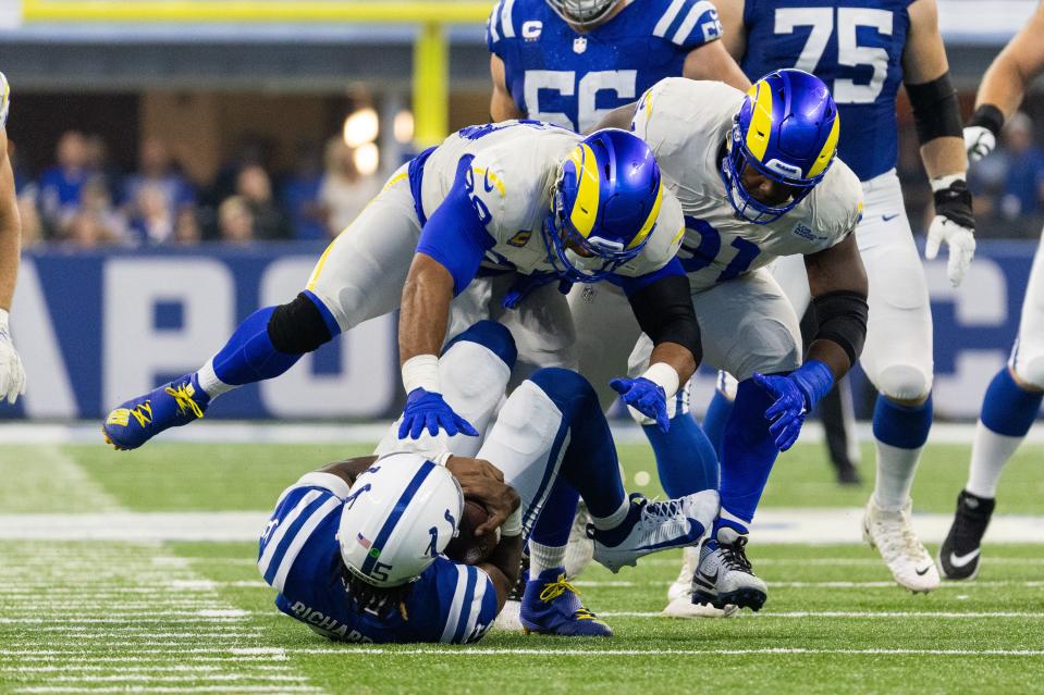 Los Angeles Rams defensive tackles Aaron Donald (99) and Kobie Turner sack Indianapolis Colts quarterback Anthony Richardson (5) in the second quarter at Lucas Oil Stadium.