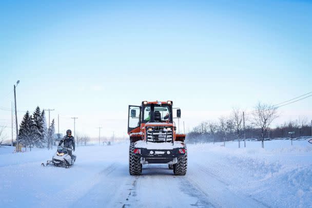 PHOTO: A man on a snowmobile speaks to a plow in the road following a winter storm that hit the Buffalo region in Amherst, New York, December 25, 2022. (Brendan Mcdermid/Reuters)