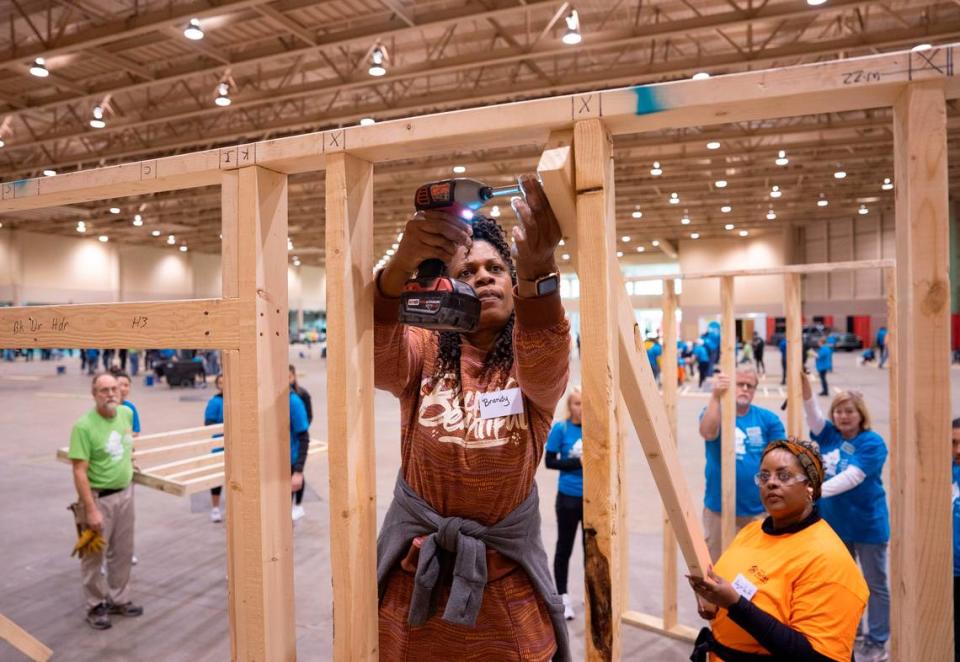 Service for Change participants will try to raise $100,000 by April 2025, which they will donate to Habitat for Humanity. In this photo, volunteer Brandy Evans, center, helps build walls for three Wichita Habitat for Humanity Homes during the organization’s 2023 Martin Luther King Day of Service event.