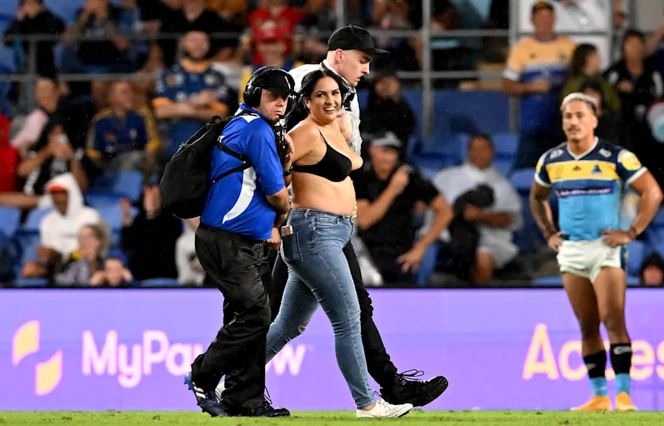 Pictured here, the pitch invader is clearly happy after being escorted from the field by security guards. 