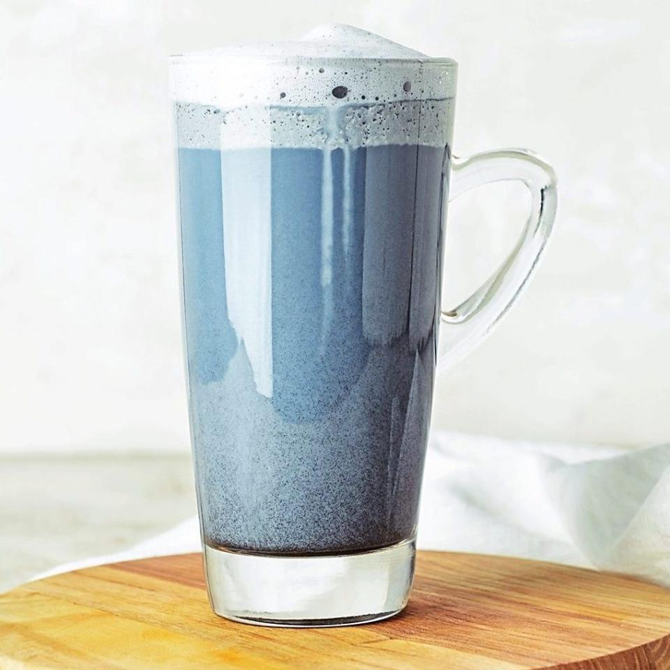 Wooden board with a Charcoal Latte on light table;