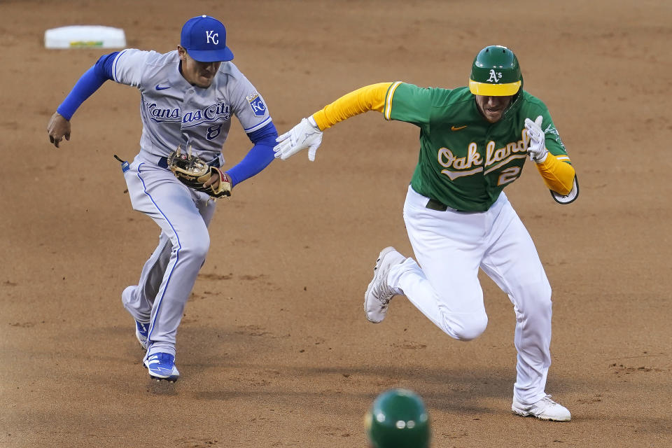 Oakland Athletics' Stephen Piscotty, right, is chased by Kansas City Royals shortstop Nicky Lopez before being tagged out while trying to advance after singling during the fifth inning of a baseball game in Oakland, Calif., Thursday, June 10, 2021. (AP Photo/Jeff Chiu)