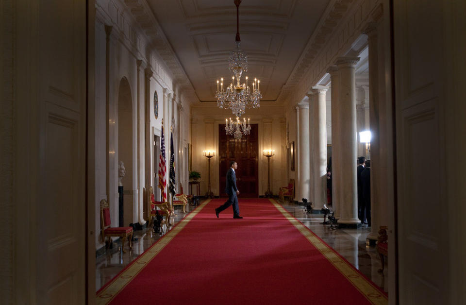 Obama walks to a podium in the Cross Hall, Grand Foyer of the White House, before making a statement regarding the American auto industry, on March 30, 2009.