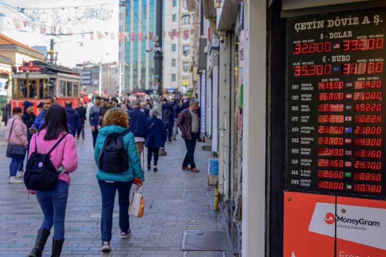 Les taux de change de la livre turque sont affichés sur l'avenue Istklal à Istanbul, le 21 mars 2024 (Yasin AKGUL)