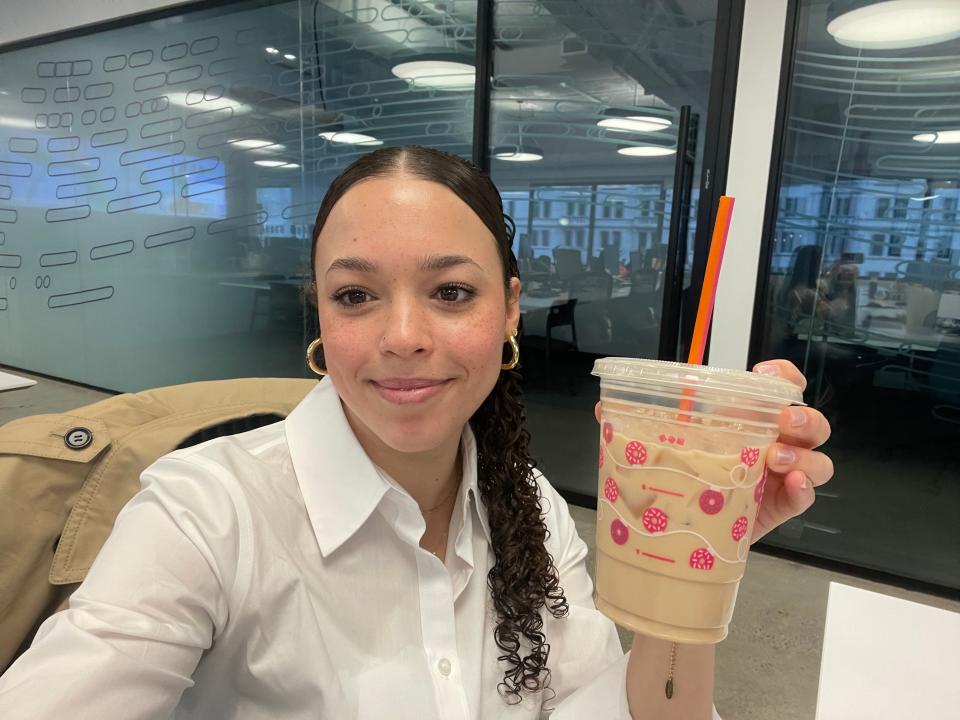 Me holding my iced vanilla latte from Dunkin'.