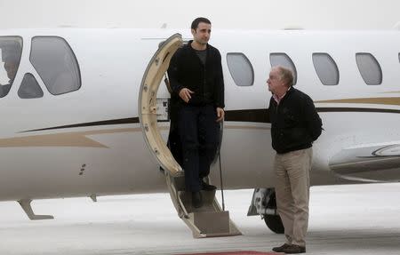 Former U.S. Marine Amir Hekmati, recently released from an Iranian prison, steps out of the plane piloted by Mike Karnowski (R), as he arrives at an airport in Flint, Michigan January 21, 2016. REUTERS/Rebecca Cook