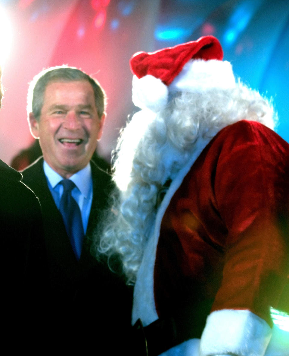 President George W. Bush and Santa Claus (Willard Scott) at the annual Christmas Tree lighting on the Ellipse on December 2, 2004 in Washington, DC. The tree lighting opens the 2004 Christmas Pageant of Peace.  (Photo by Ron Sachs-Pool/Getty Images)