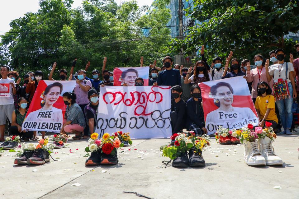 Anti-coup protesters gather at Kamayut township in Yangon, Myanmar Thursday, April 8, 2021, with shoes willed with flowers. They walked through the markets and streets of Kamayut township with slogans to show their disaffection for military coup. A sign, center, reads " Kamayut Youth Strike." (AP Photo)