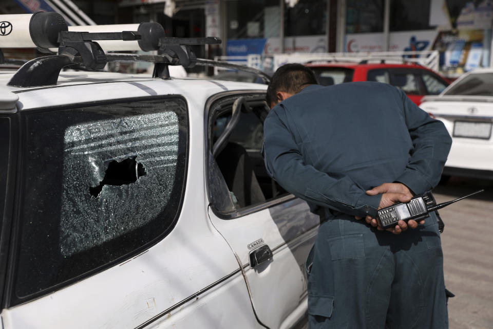 An Afghan police inspect the car after a director of Afghanistan's Government Information Media Center Dawa Khan Menapal was shot dead in Kabul, Afghanistan, Friday, Aug. 6, 2021. The Taliban shot and killed the director of Afghanistan's Government Information Media Center on Friday, the latest killing of a government official and one that comes just days after an assassination attempt on the acting defense minister. (AP Photo/Rahmat Gul)