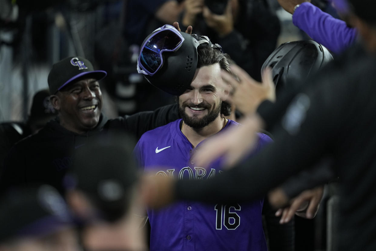 Colorado Rockies' Sam Hilliard celebrates in the dugout after hitting a home run during the sixth inning of a baseball game against the Los Angeles Dodgers in Los Angeles, Friday, Sept. 20, 2024. (AP Photo/Ashley Landis)