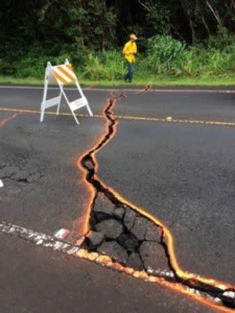 USGHV0 scientists measure the width of cracks in the road in the Kilauea east rift zone eruption, using a thermal camera that looks for heat within the cracks, in Hawaii, U.S. May 7, 2018. Picture taken on May 7, 2018. USGS/Handout via REUTERS
