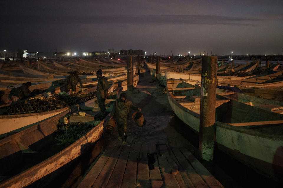 Tras una jornada en el mar, pescadores descargan sus capturas en el puerto de Nuadibú, Mauritania, el 27 de noviembre de 2021. (AP Foto/Felipe Dana)