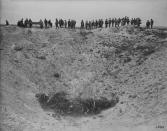 <p>Canadian journalists are seen on the lip of one of the largest craters on Vimy Ridge in July 1918. Photo from Library and Archives Canada. </p>