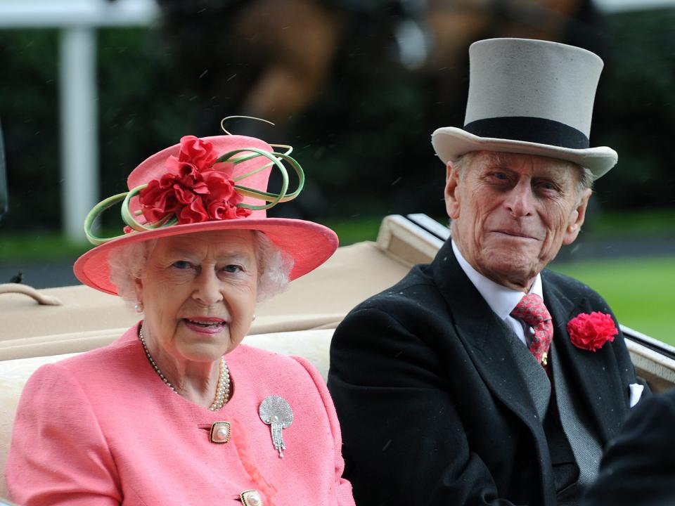 Queen Elizabeth in pink dress and hat and Prince Philip in black suit and gray top hat.