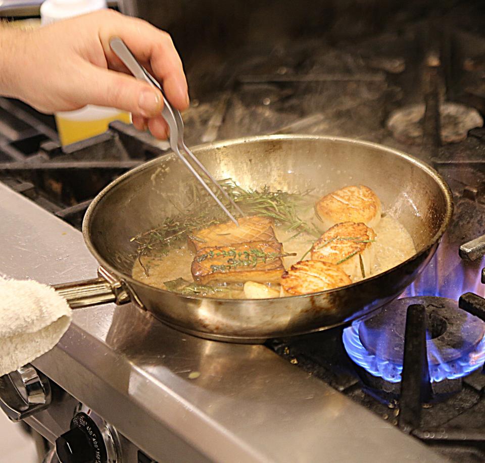 Steve Taplin, Chef at Bar Reverie in Greenville, cooks scallops with king trumpet mushrooms.