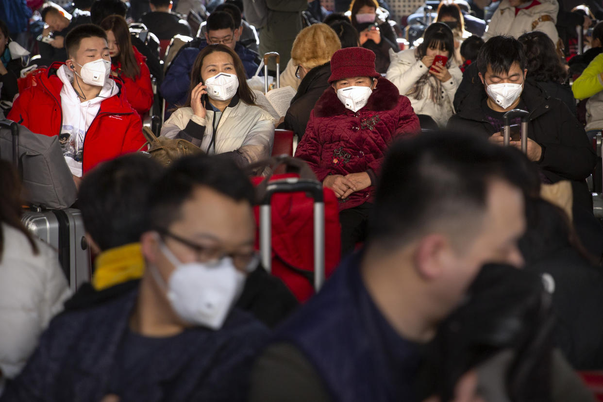 Reisende am Pekinger Westbahnhof tragen als Schutzmaßnahme gegen die Verbreitung des Corona-Virus Mundschutz (Bild: Mark Schiefelbein/AP/dpa)