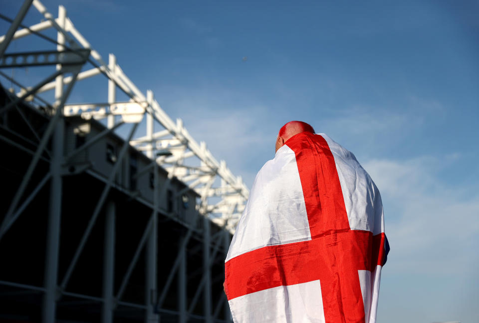 Image: An England fan wears a flag outside the stadium during the international friendly match between England and Austria at Riverside Stadium (Alex Pantling / The FA via Getty Images)