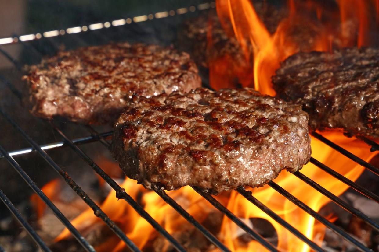 burgers patties grilling over open flame