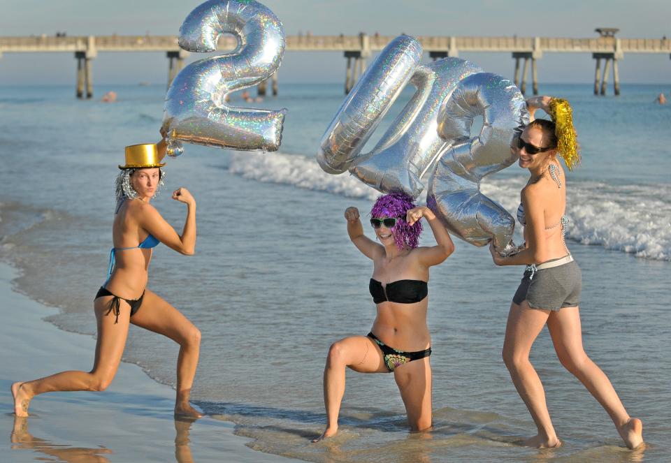 Left to right, Kaci Halstead, Terell Reglin and India Anderson strike a pose with their 2012 balloons after taking part in the New Year's morning Polar Plunge at Jacksonville Beach with about 500 others participating.