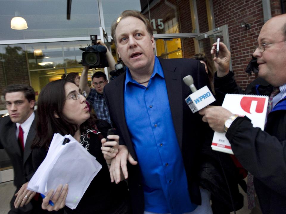 Former Boston Red Sox pitcher Curt Schilling, center, is followed by members of the media as he departs the Rhode Island Economic Development Corporation headquarters in Providence, R.I., Monday, May 21, 2012. Schilling and Rhode Island's economic development agency met Monday to discuss the finances of his troubled video company. (AP Photo/Steven Senne)