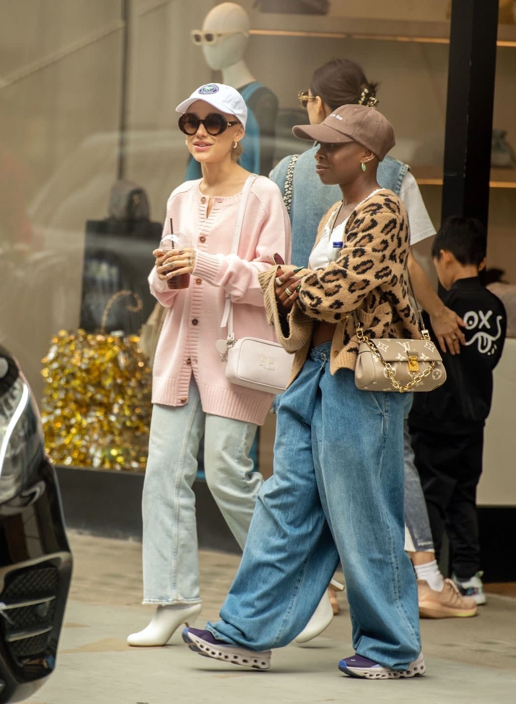 ariana grande and cynthia ervio walk on sidewalk