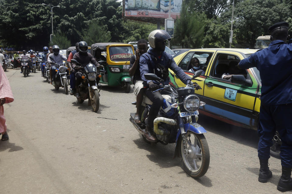 A police officer controls traffic on a street in Conakry, Guinea Thursday, Sept. 9, 2021. Guinea's new military leaders sought to tighten their grip on power after overthrowing President Alpha Conde, warning local officials that refusing to appear at a meeting convened Monday would be considered an act of rebellion against the junta. (AP Photo/ Sunday Alamba)