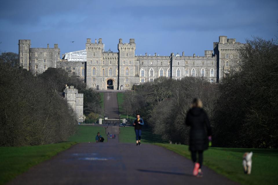 A woman walks with a dog along the Long Walk at Windsor Castle in Windsor, west of London on January 9, 2020. - Britain's Prince Harry and his wife Meghan stunned the British monarchy on Wednesday by quitting as front-line members -- reportedly without first consulting Queen Elizabeth II. In a shock announcement, the couple said they would spend time in North America and rip up long-established relations with the press. Media reports said the Duke and Duchess of Sussex made their bombshell statement without notifying either Harry's grandmother the monarch, or his father Prince Charles. (Photo by DANIEL LEAL-OLIVAS / AFP) (Photo by DANIEL LEAL-OLIVAS/AFP via Getty Images)