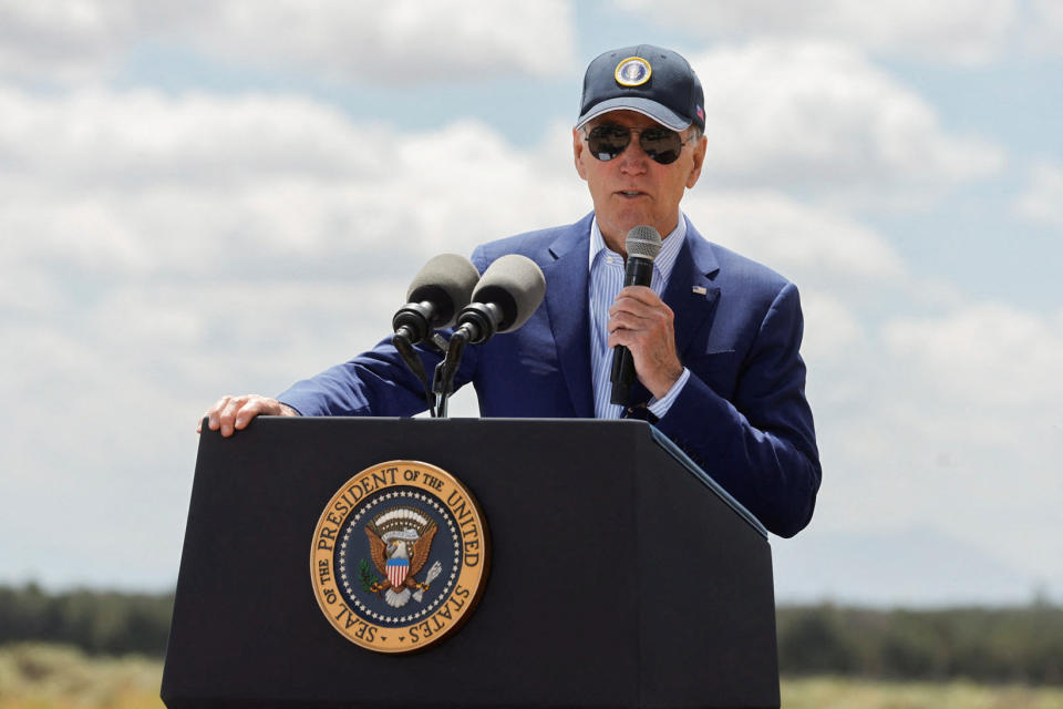 President Biden, in baseball cap, at the microphone.