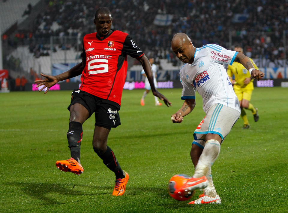 Rennes' Abdoulaye Doucoure, left, challenges for the ball with Marseille's Andre Ayew , during their League One soccer match, at the Velodrome Stadium, in Marseille, southern France, Saturday, March 22, 2014. (AP Photo/Claude Paris)