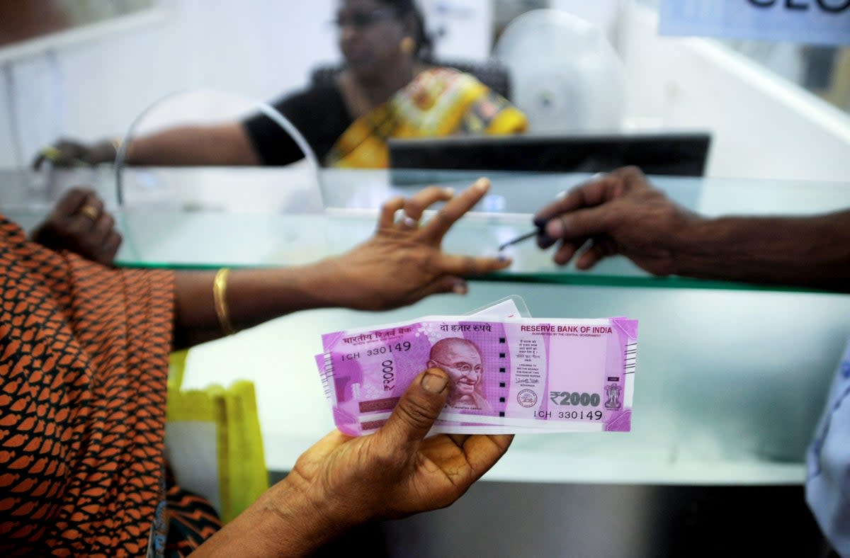 File. An Indian woman displays her 2000 rupee notes as she has her finger inked with indelible ink after exchanging withdrawn 500 and 1000 rupee banknotes at a bank in Chennai in 2016  (AFP via Getty Images)