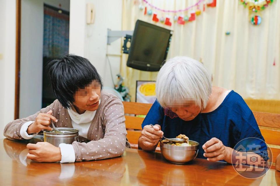 在牧心夜間照護機構，謝秀琴（右）和蔡美莉（左）一起吃飯。老憨兒體力總在午後快速衰退，沐浴、晚餐後，就無法再安排太多的活動。