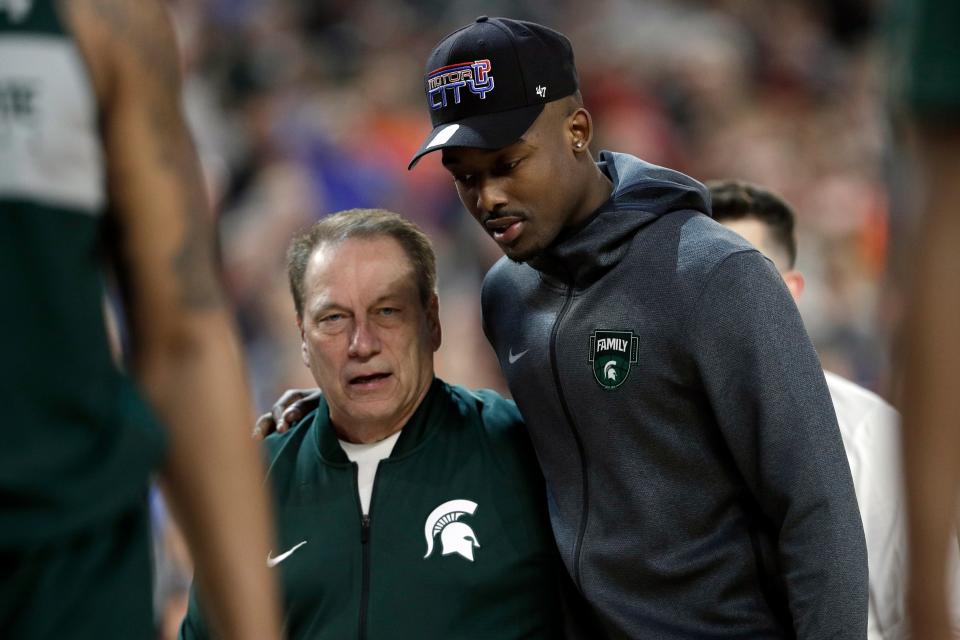 Michigan State head coach Tom Izzo walks with injured guard Joshua Langford during a practice session for the Final Four, April 5, 2019, in Minneapolis.