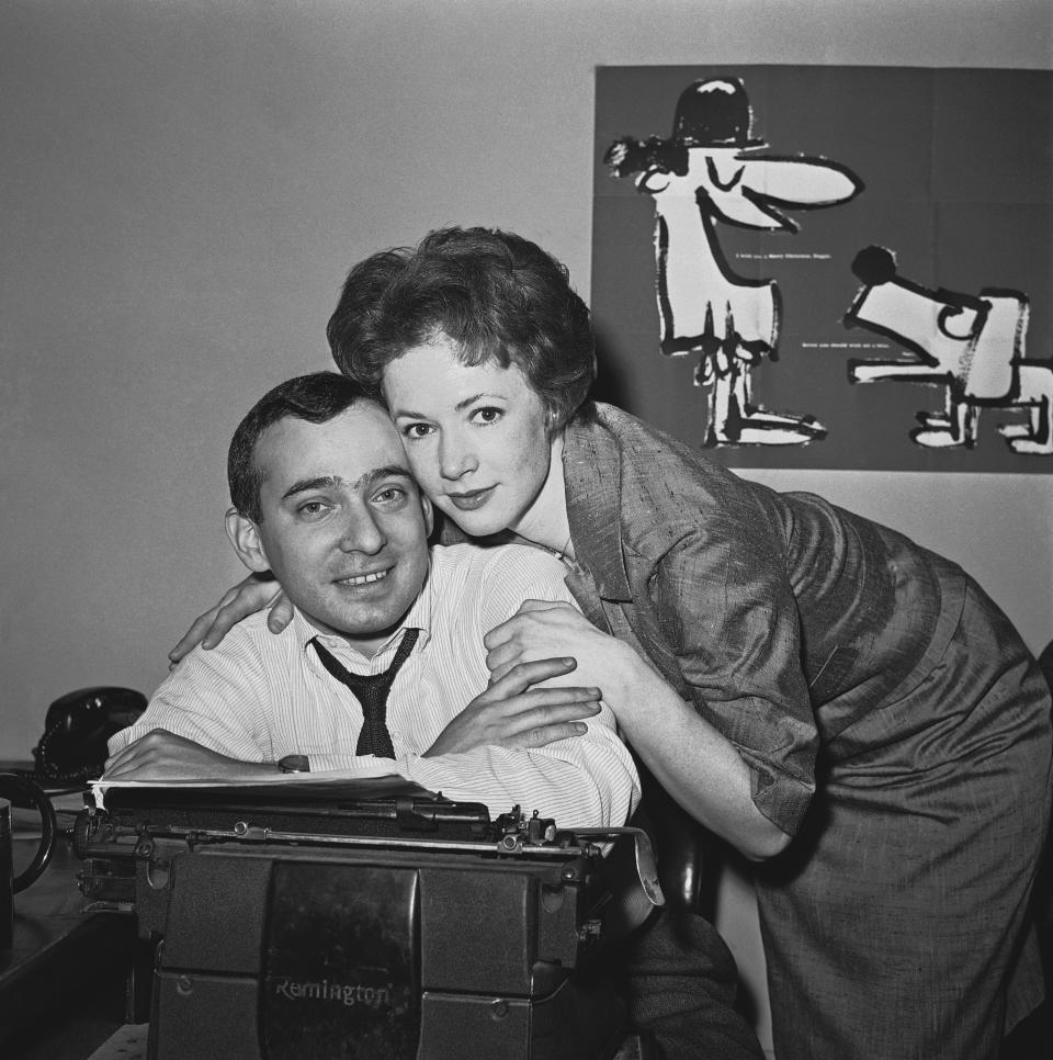 FILE - Actress Piper Laurie hugs her husband-to-be, drama reporter and critic Joseph M. Morgenstern, at his desk at the Herald-Tribune in New York, shortly after her parents announced their engagement, Dec. 28, 1961. Laurie, the strong-willed, Oscar-nominated actor who performed in acclaimed roles despite at one point abandoning acting altogether in search of a “more meaningful” life, died early Saturday, Oct. 14, 2023, at her home in Los Angeles. She was 91. (AP Photo/John Lent, File)