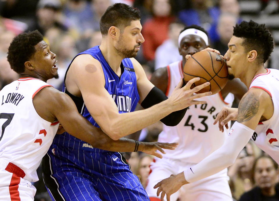 Orlando Magic center Nikola Vucevic , second from left, is pressured by Toronto Raptors guard Kyle Lowry (7), Pascal Siakam (43) and Danny Green during first half NBA basketball action in Toronto on Sunday, Feb. 24, 2019. THE CANADIAN PRESS/Frank Gunn/The Canadian Press via AP)